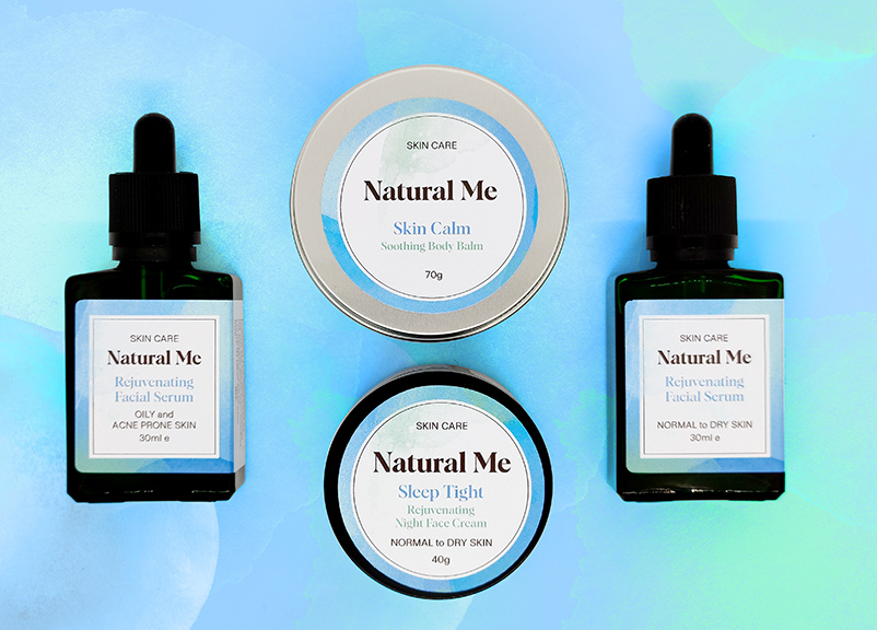 Natural Me skincare products are laid out on a watercolour background