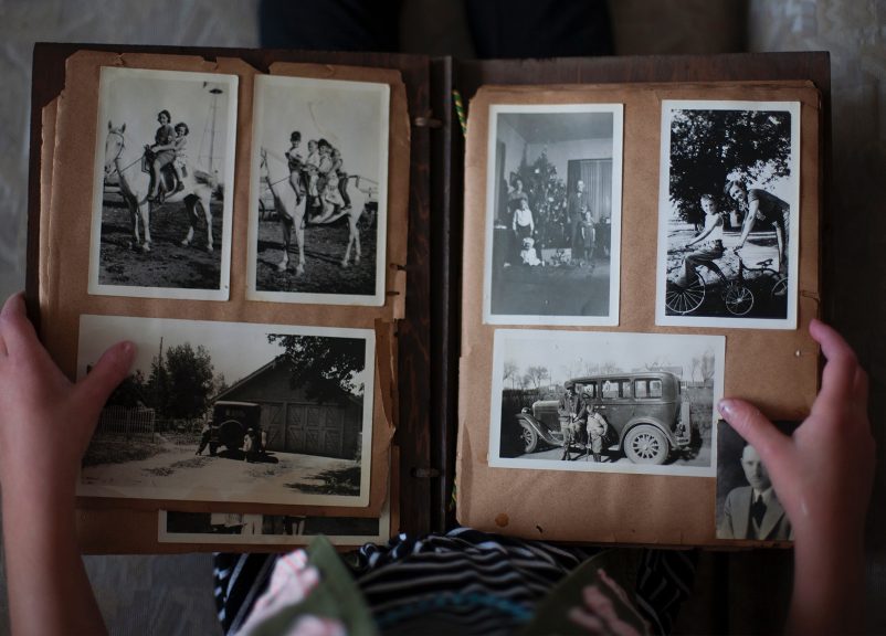 an old photo album open to show a selection of black and white photos
